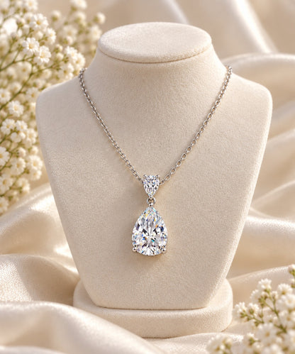 Sterling silver pear-shaped pendant with a simulated clear stone on a necklace bust