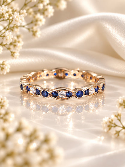 Twilight Hollow Blue Stacking Band, gold-tone scalloped band with blue and white cubic zirconia stones, on white satin with baby's breath